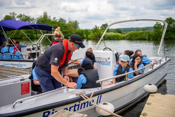 Children aboard an accessible boat at the Rivertime Regatta.